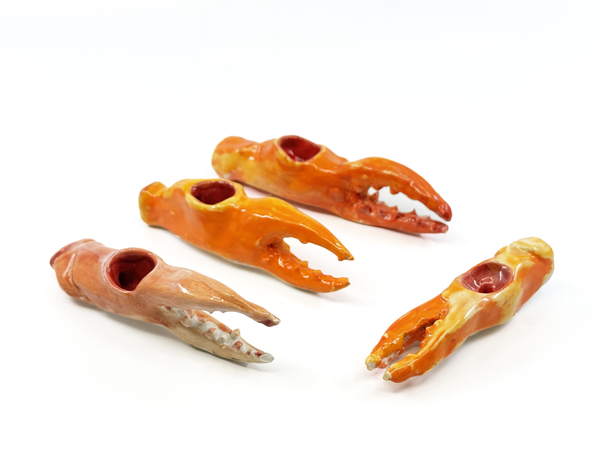 Four ceramic crab claws on a white background